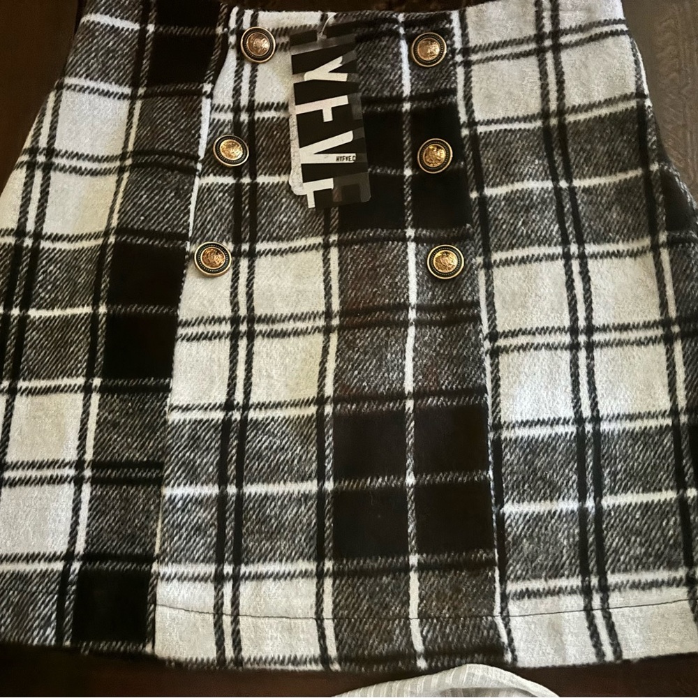 Plaid mini skirt with buttons on front.